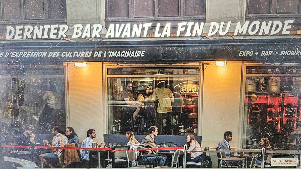A bar named 'Dernier Bar Avant La Fin Du Monde' with outdoor seating and people sitting outside. 5
