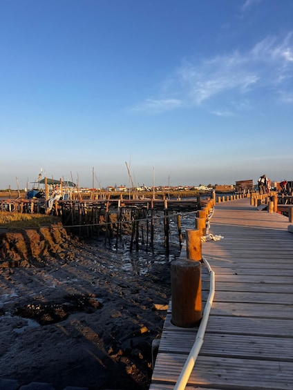 A wooden pier extending into a body of water, with a clear sky above. 4