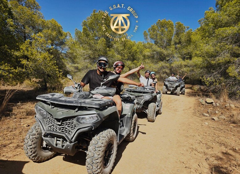 A group of people riding ATVs on a dirt trail surrounded by trees. 2