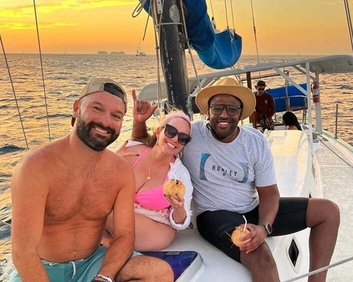 Three people on a sailboat at sunset. 5