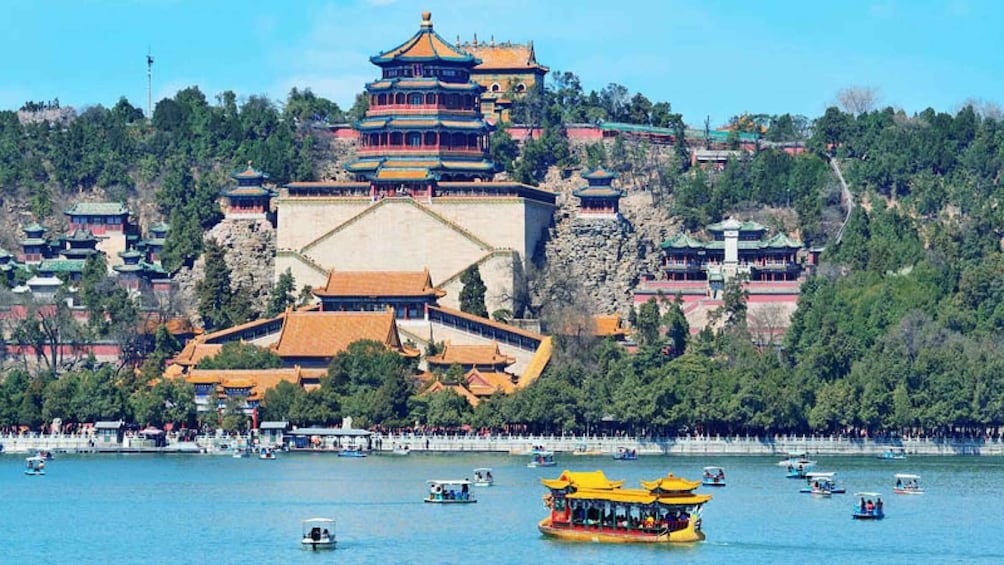 A traditional Chinese pagoda on a hill with a lake in the foreground. 1