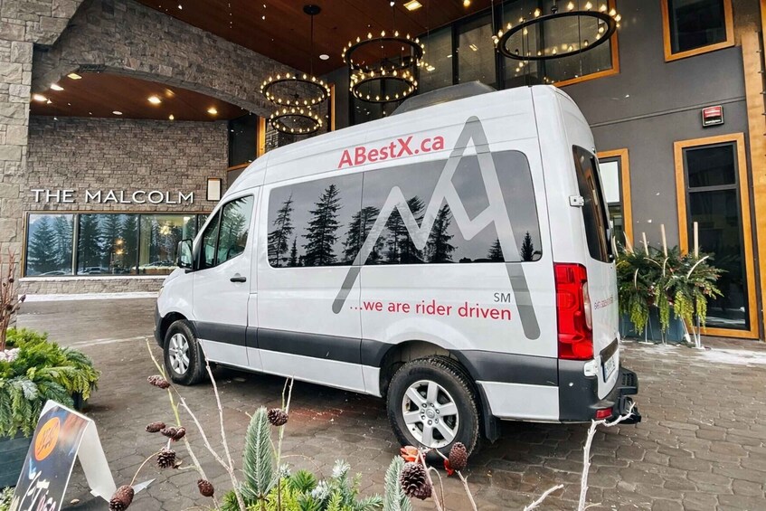 A white van parked in front of a building with a sign reading "THE MALCOLM". 5
