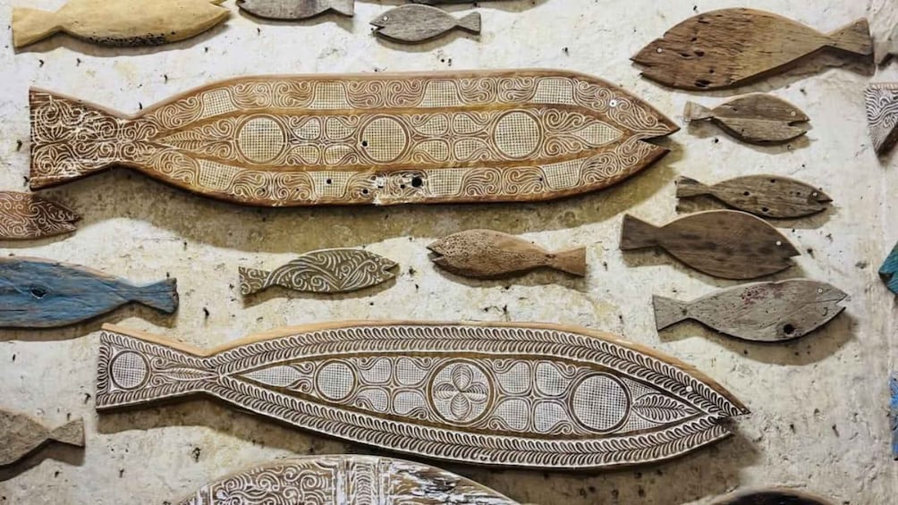 A wall decorated with fish-shaped tiles, some with intricate patterns and others plain. 2