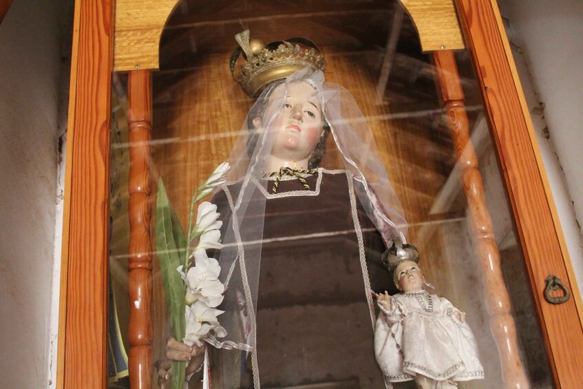 A statue of a woman holding a child, with a crown and a veil. 3