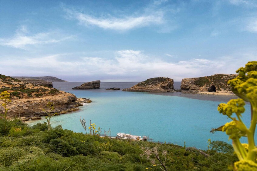 A coastal landscape with clear turquoise waters, rocky outcrops, and a boat on the shore. 2