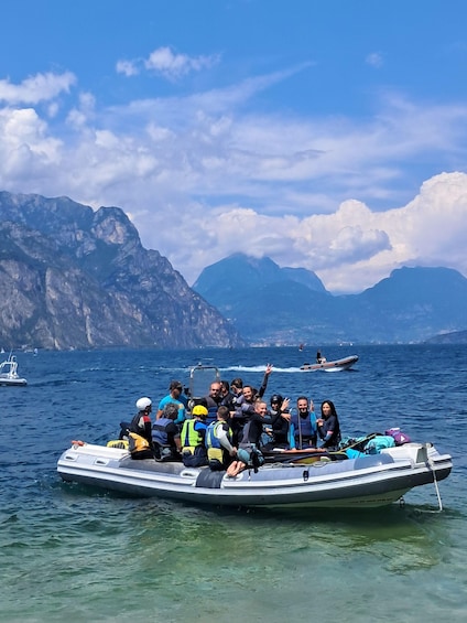 A group of people on a small boat in a body of water with mountains in the background. 1