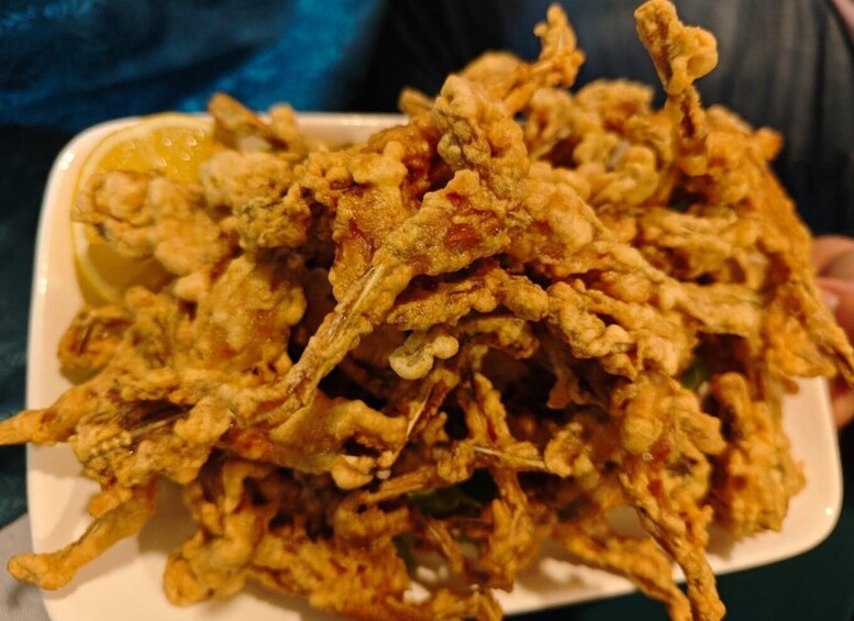 A plate of fried food, likely tempura, with a lemon wedge on the side. 2