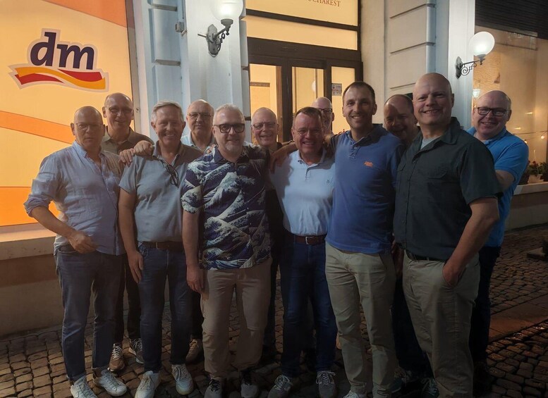A group of men standing in front of a building with a 'dm' logo. 3