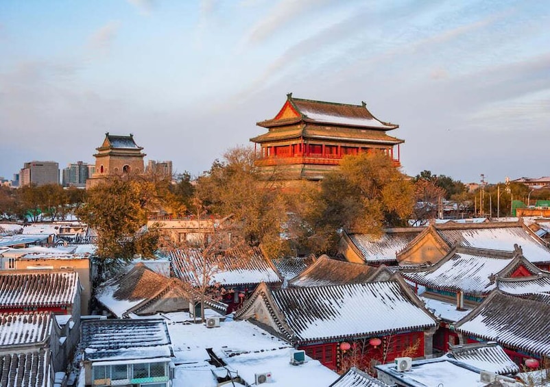 A traditional Chinese building with red walls and a tiled roof, surrounded by snow-covered rooftops and trees. 5
