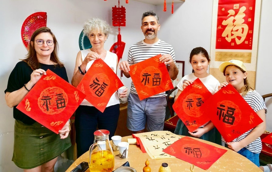 A group of people holding red envelopes with Chinese characters. 1