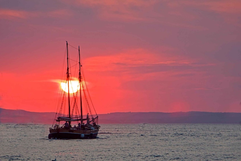 A sailing boat on calm waters during sunset. 1