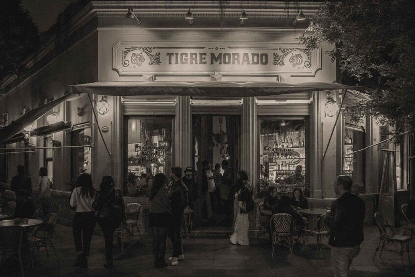 A bustling outdoor cafe named TIGRE MORADO with people dining and walking around. 5