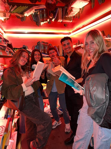 A group of people in a room filled with bookshelves and books. 1
