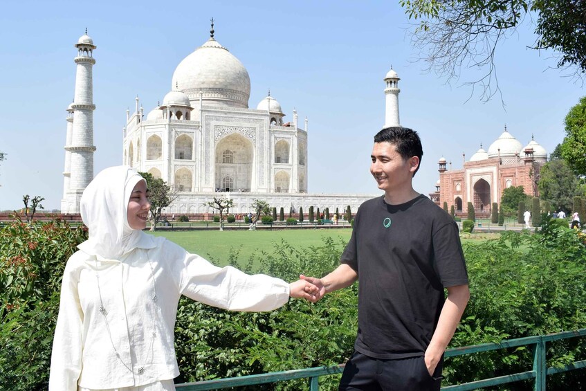 Deux personnes se tenant la main devant le Taj Mahal. 3