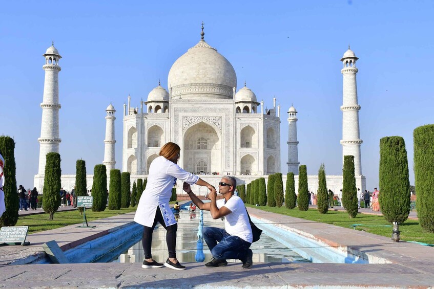 Un homme à genoux devant le Taj Mahal, une femme se tenant à ses côtés. 5