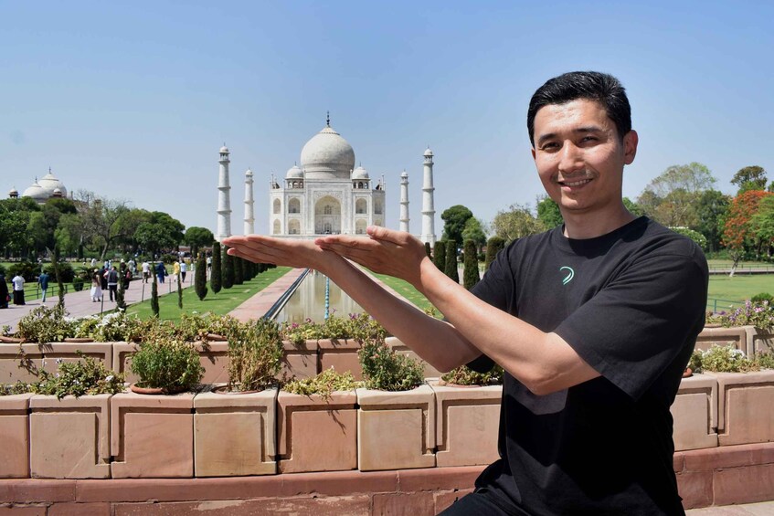 Une personne se tient debout, les bras ouverts, devant le Taj Mahal. 2