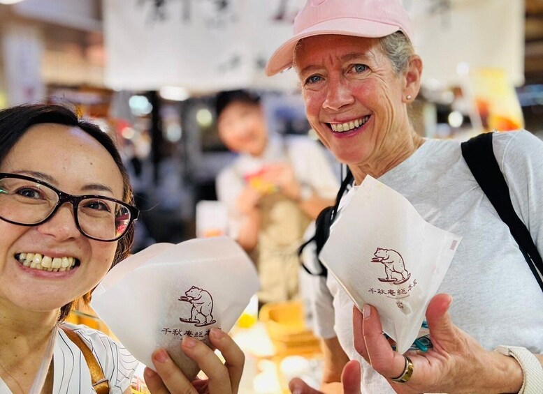 Two people holding white paper bags with a bear logo. 4