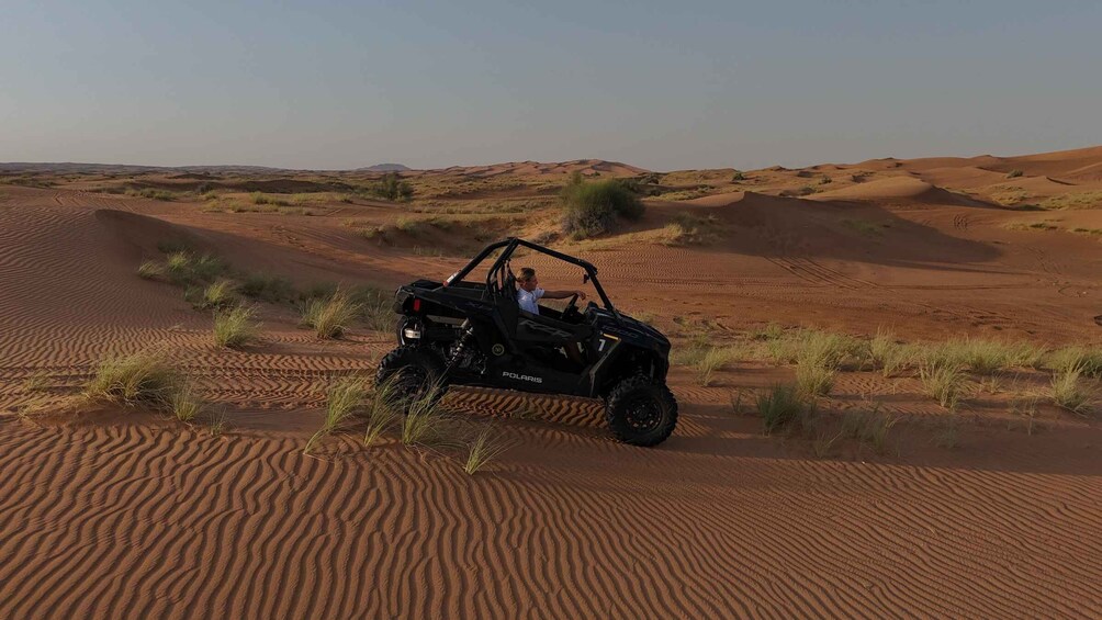 A black Polaris ATV on a sandy dune in a desert landscape. 5