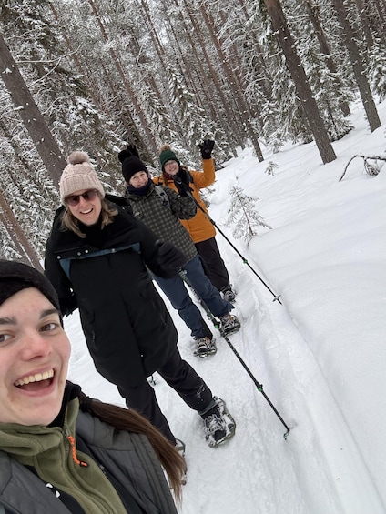 A group of people hiking in a snowy forest. 2