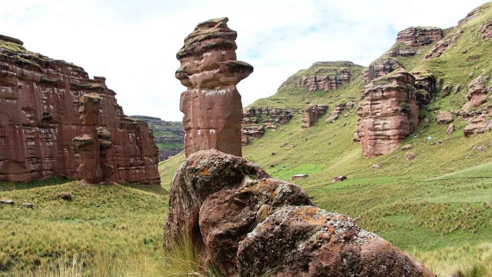 A rocky landscape with prominent rock formations and a grassy hill. 3