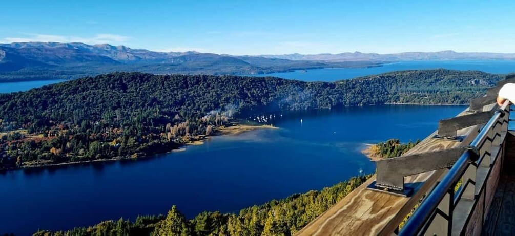 A lake surrounded by forested hills and mountains in the distance. 4