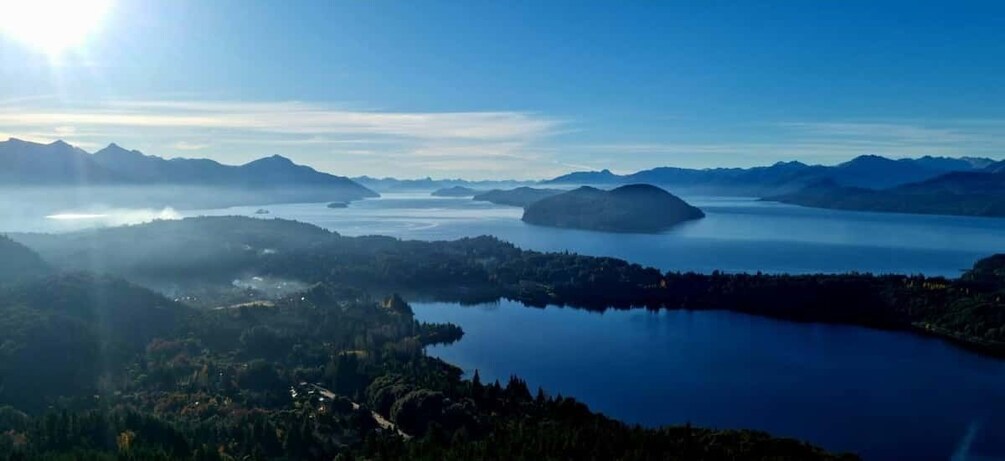 A lake surrounded by mountains and forested areas. 3