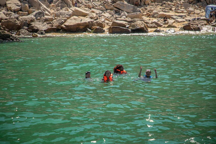 People swimming in a river surrounded by rocks. 5