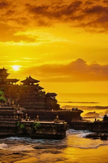 A temple complex with traditional architecture by the sea during sunset. 4