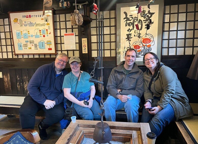 A group of people sitting in a traditional Japanese restaurant with wooden furniture and decor. 1