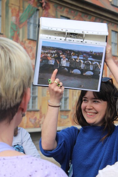 A person holding a tablet displaying a photo of a bridge. 3