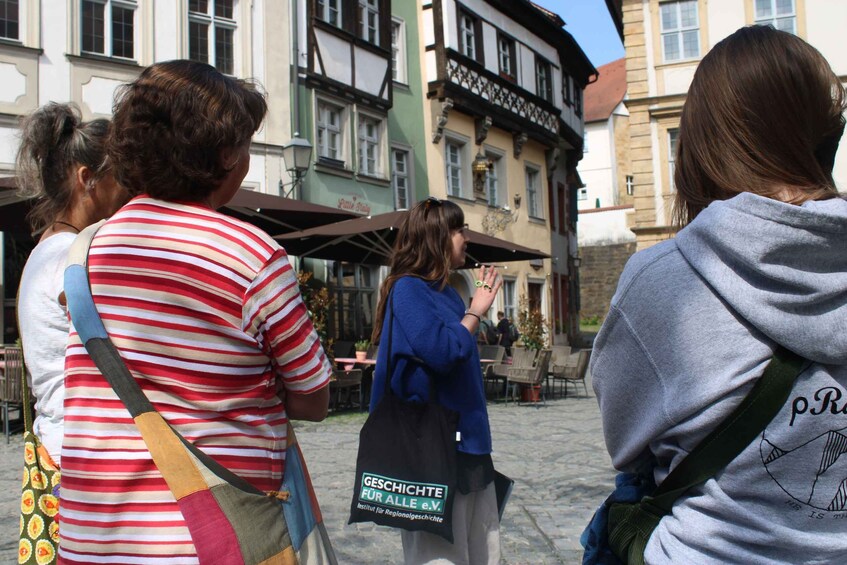People standing in a cobblestone street with historic buildings. 2