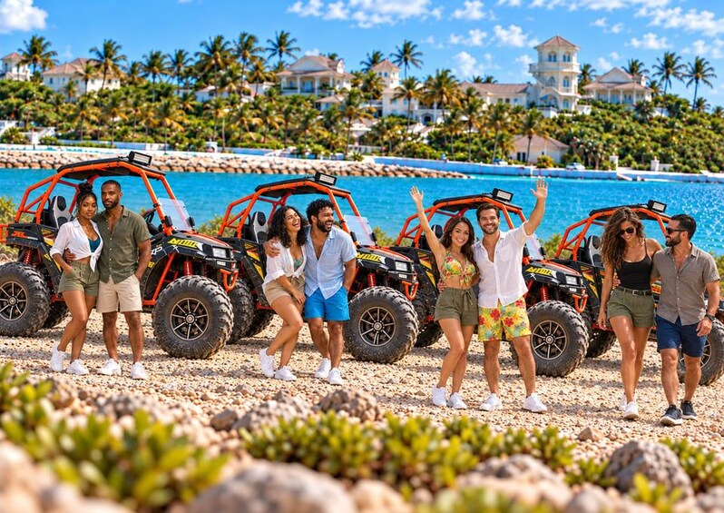 A group of people on a beach with ATVs and a large house in the background. 1