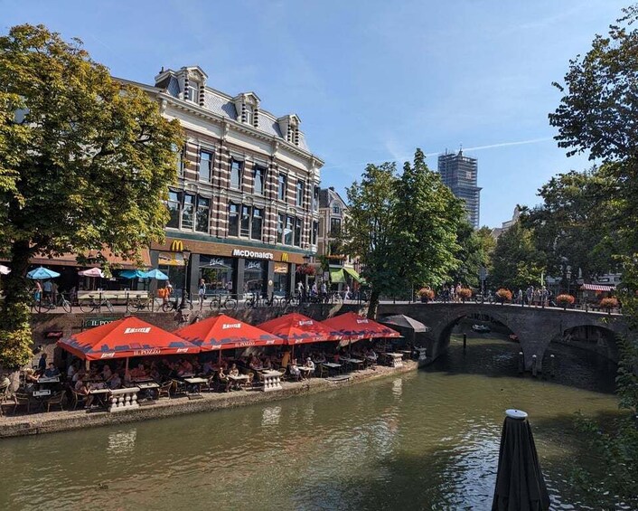 A riverside café with outdoor seating, a McDonald's, and a bridge. 5