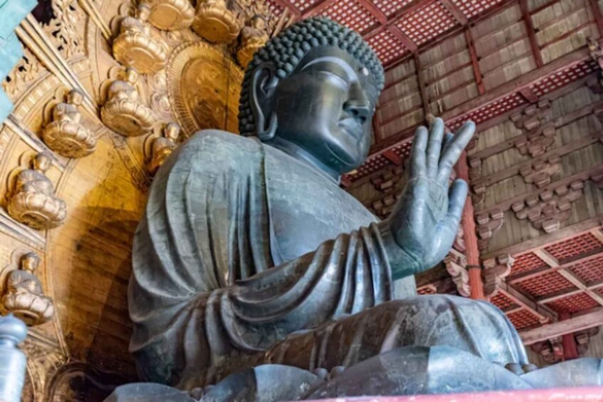 A large Buddha statue in a temple with intricate golden decorations and a red and gold roof. 3