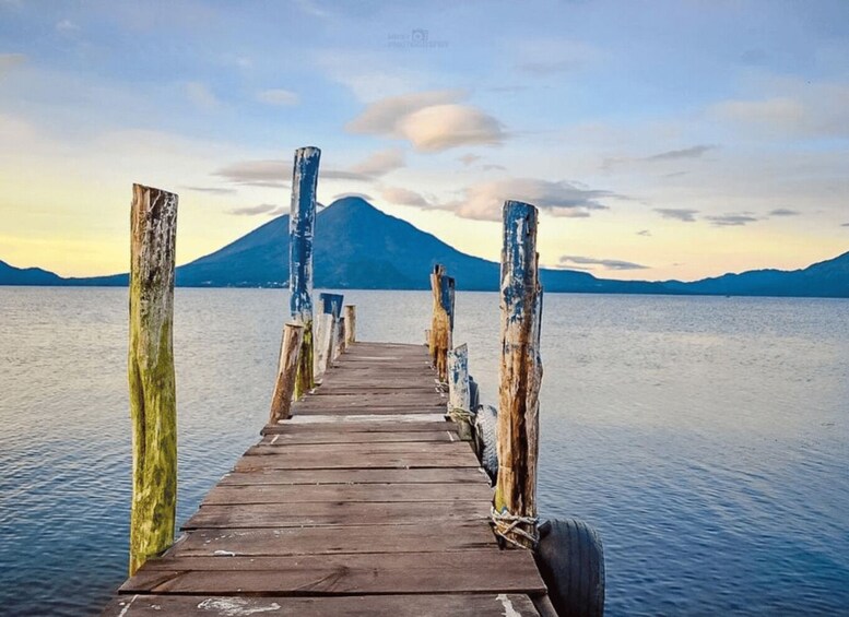 A wooden pier leading to a calm lake with a mountain in the background. 5