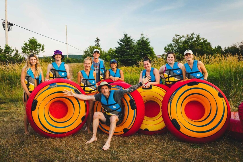 A group of people in blue life vests holding large inflatable rings. 5