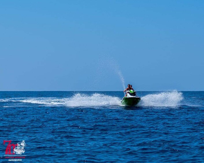 A person jet-skiing on a clear blue ocean. 3