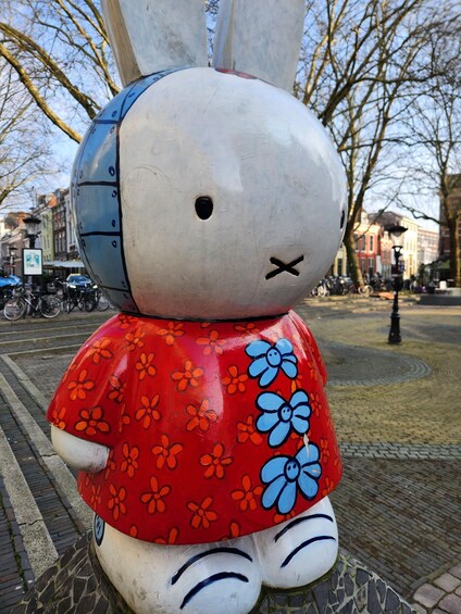 A large, colorful sculpture of a rabbit with a red dress and blue flowers. 1