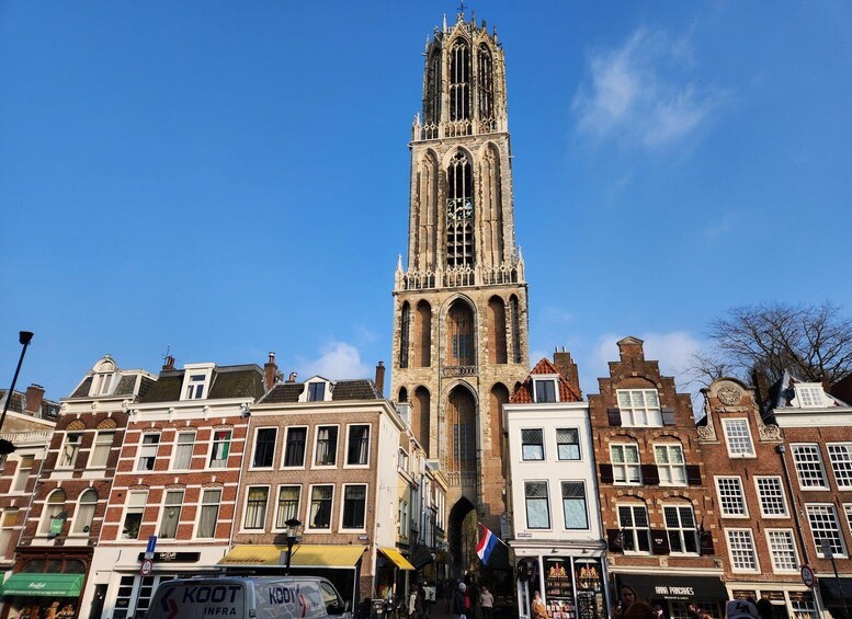 A historic church tower with Gothic architecture, surrounded by traditional European buildings. 2