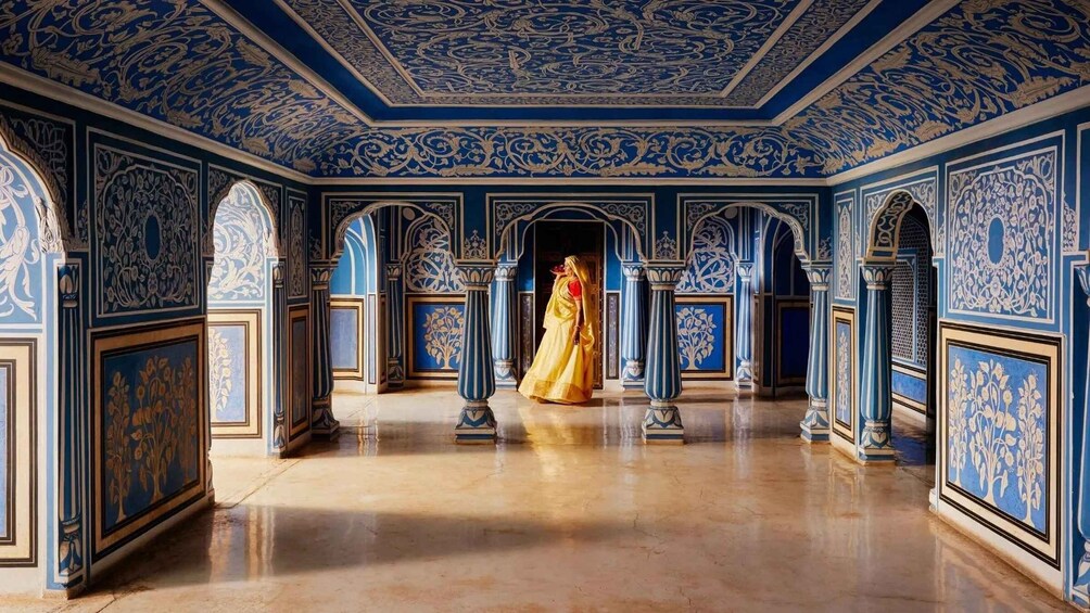 A grand hall with blue and gold ornate ceiling and walls, featuring intricate floral patterns and columns. 3