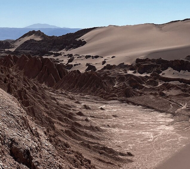 A desert landscape with sand dunes and rocky terrain. 5