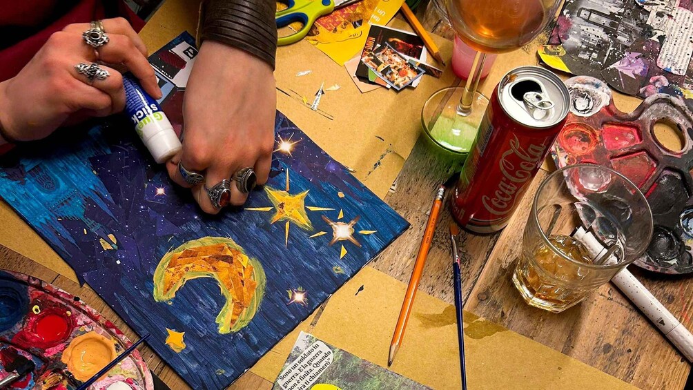 A person painting a starry night scene with a crescent moon on a canvas. 3