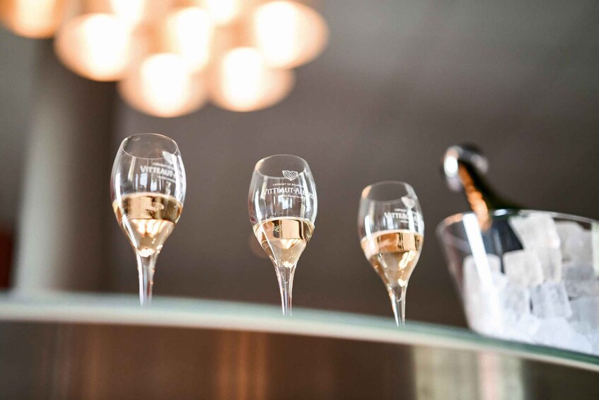 Three champagne flutes with a bottle of champagne in an ice bucket. 3