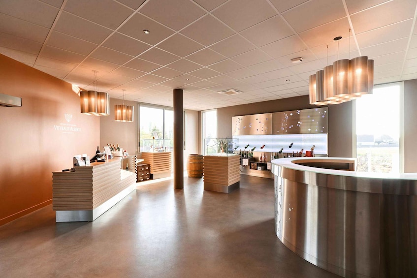 A modern bar with a wooden counter, metal fixtures, and a large window. 1