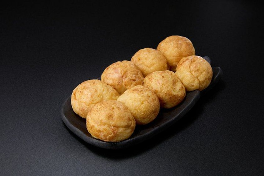 Une assiette de viennoiseries dorées et croustillantes, posée sur une surface sombre. 3