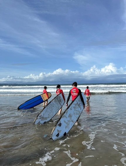 A group of people with surfboards walking towards the ocean. 2