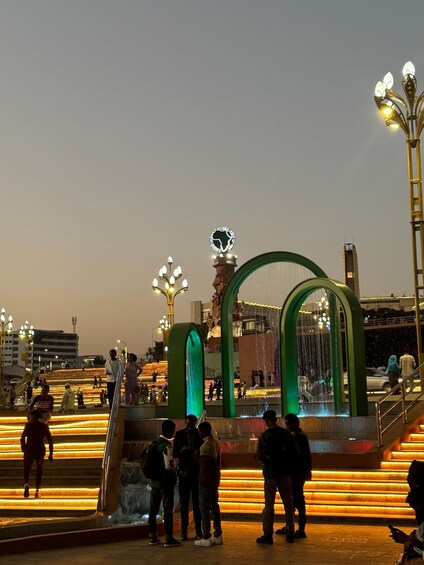 A public square with illuminated steps and a fountain. 4