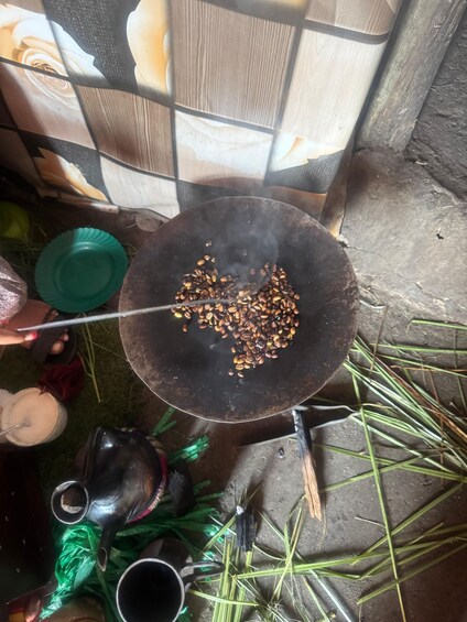 A black pan with coffee beans being roasted on a stove. 5