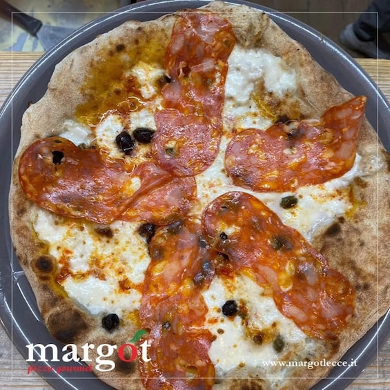 A pizza with pepperoni and cheese on a round pan. 4
