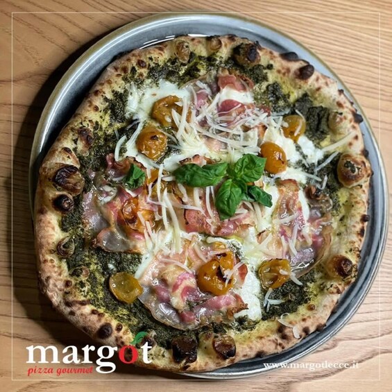 A pizza with toppings like cheese, basil, and olives on a wooden table. 4